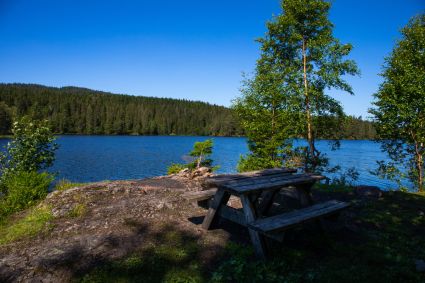 Vannet Store Åklungen i Nordmarka. Bord og benk foran vannet